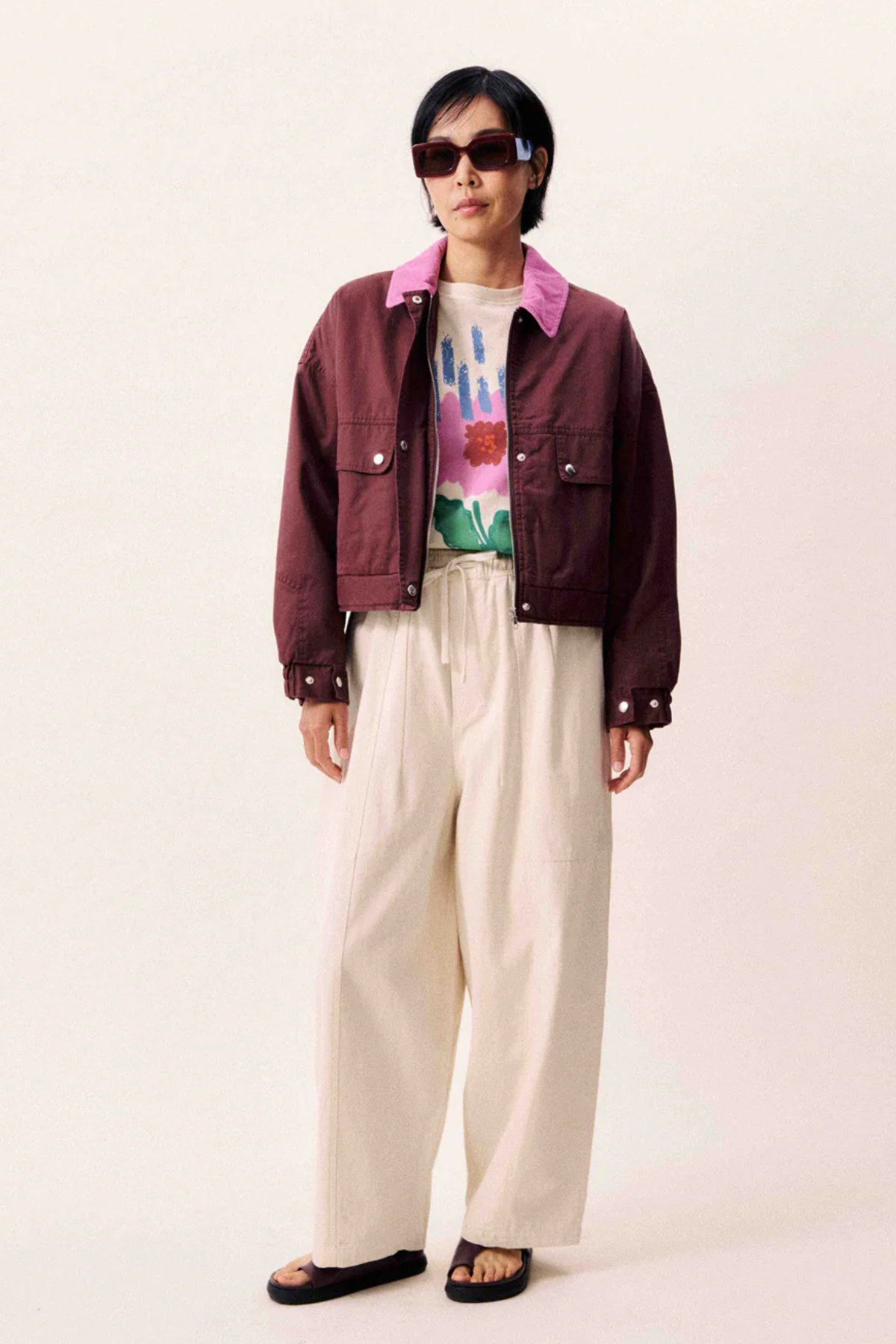 Wide-legged beige canvas trousers with elasticated waist and drawstring.