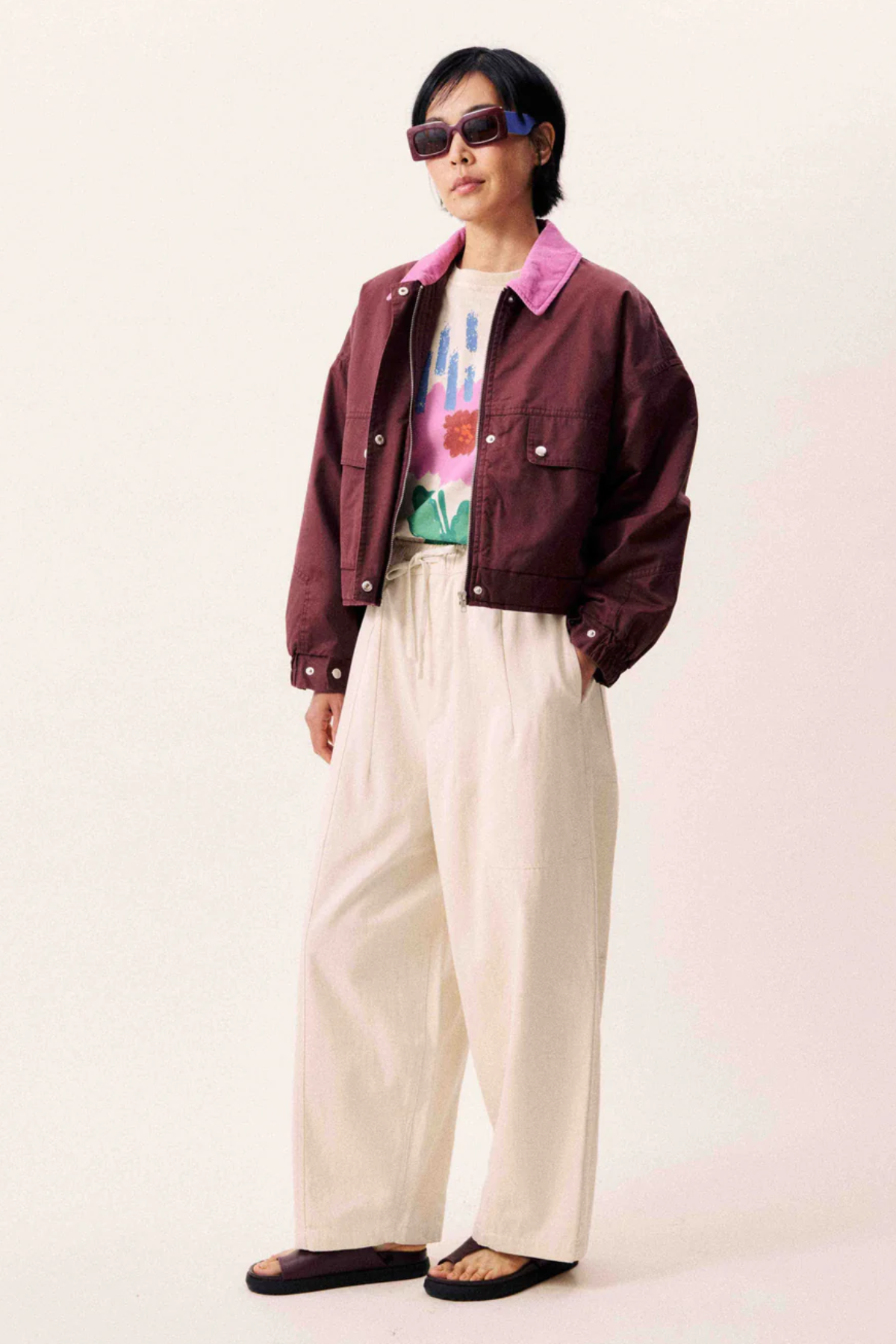 Wide-legged beige canvas trousers with elasticated waist and drawstring.
