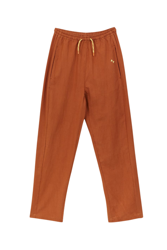 Rust coloured textured cotton trousers with bright yellow drawstring and elasticated waist.