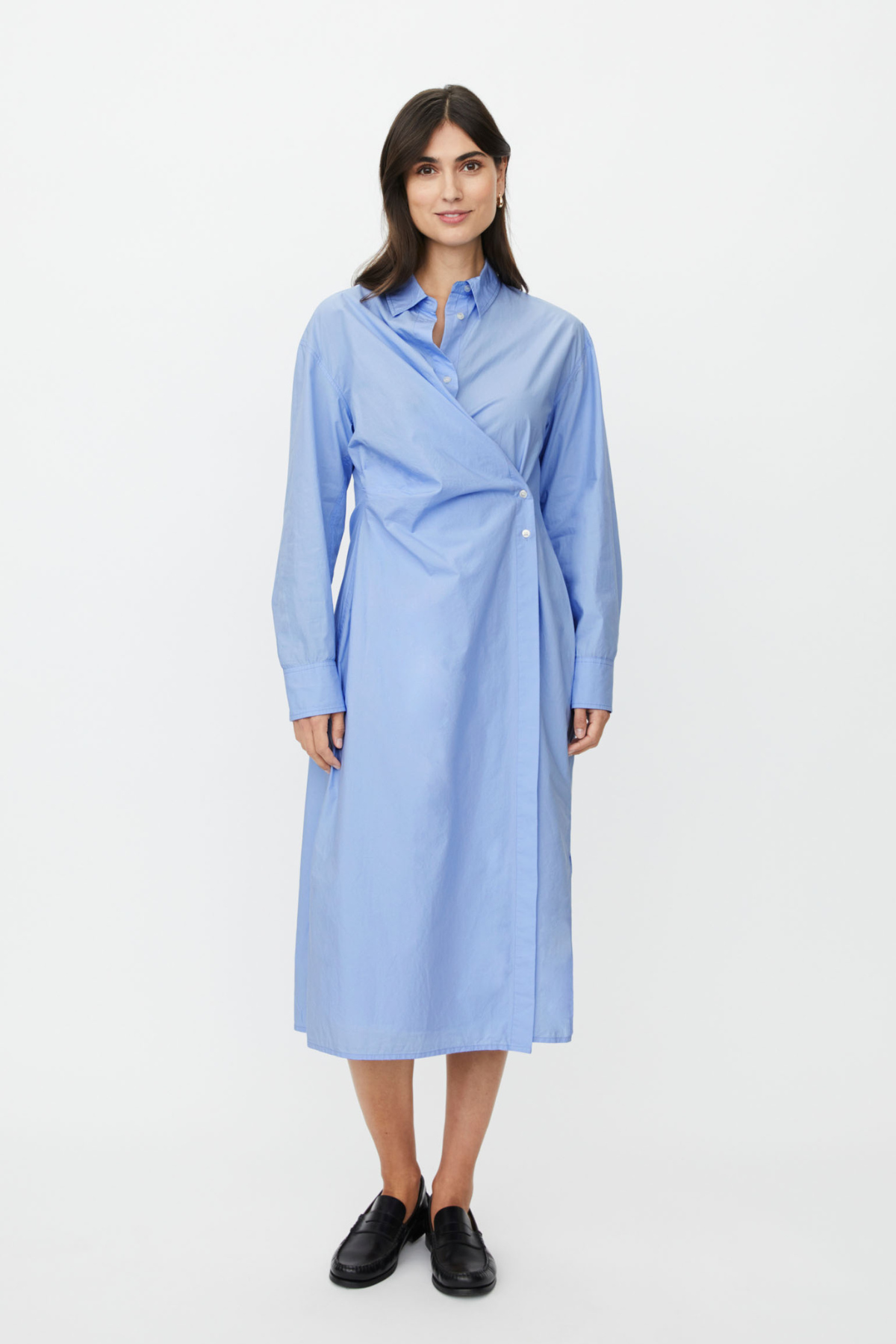 Oxford blue mid-length shirt dress with wrap detail and side buttoning. Classic collar and cuffs, a contemporary take on the shirt dress.